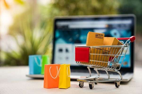 A laptop Screen - A shopping trolley- full of shopping bags